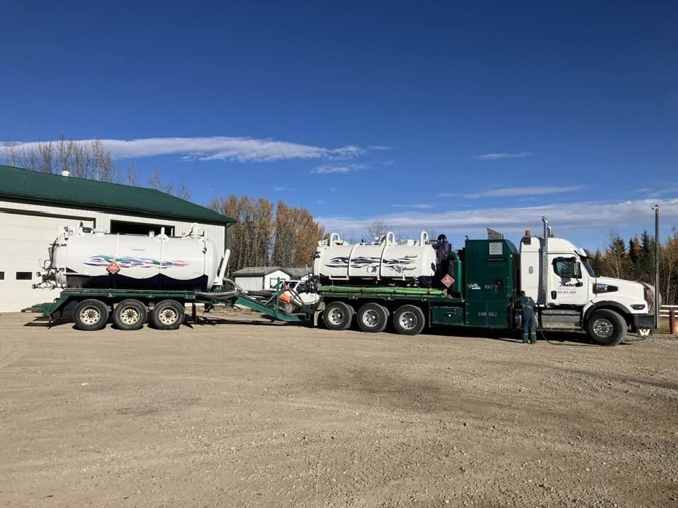 Mateo tractor and pup trailer with white tanks and green decks parked at the shop
